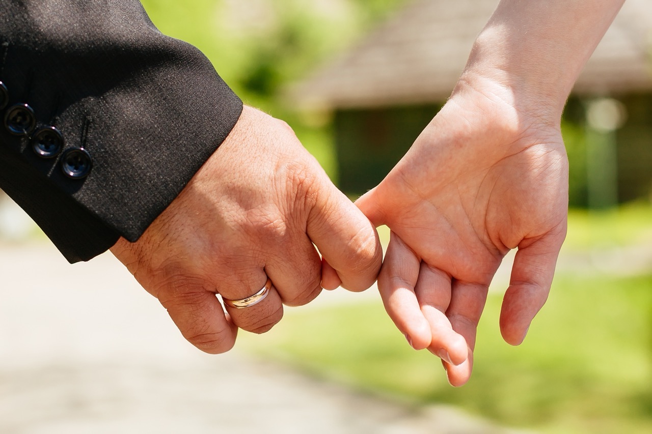 Closeup Hands of a Couple Held Together Focus on Ring. life changes life insurance review marriage